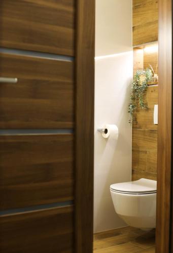 a bathroom with a toilet and a wooden door at Holiday Home Mali Medo in Gospić