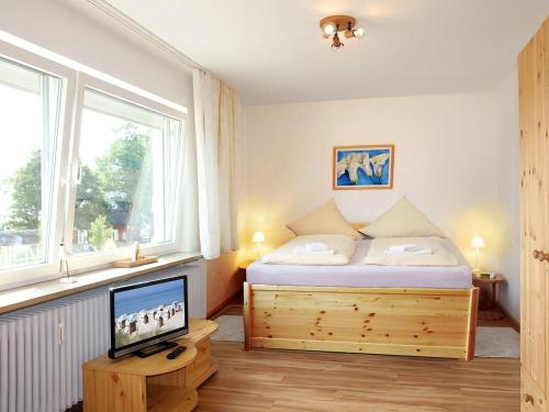 een slaapkamer met een bed, een tv en een raam bij STR-101-Strandallee-124-Seeblick in Scharbeutz