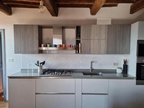 a kitchen with white cabinets and a sink at Tuscany boutique apartment in Manciano