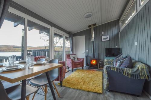 a living room with a table and a dining room at Loch Aweside Forest Cabins in Dalavich