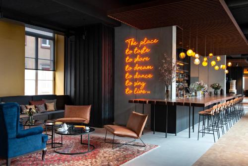 a bar in a room with chairs and a table at Hôtel LÉONOR the place to live in Strasbourg