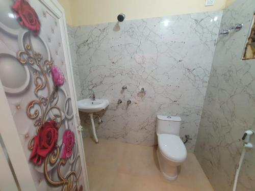 a bathroom with a toilet and a sink at Hotel Cosy Inn in Digha
