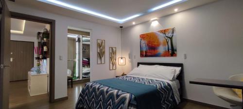 a bedroom with a bed and a bathroom with a sink at Suite de Lujo, Piso Alto, junto Parque Carolina, Generador electrico in Quito