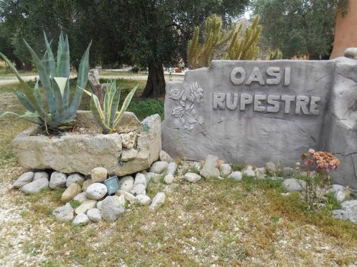 a sign for an oasis outpost with a plant at Oasi Rupestre in Montescaglioso