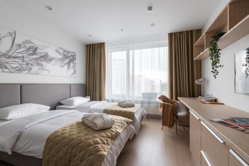 a hotel room with two beds and a desk at Apart-hotel YE'S Botanica in Moscow