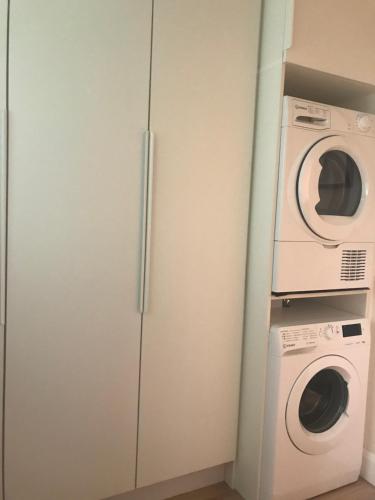 un armario blanco con lavadora y lavadora en Central town location apartment, en Enniscorthy