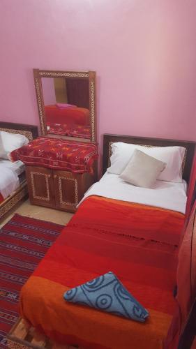 a bedroom with two beds and a mirror at Chez Said (Happy People) Apartment in Merzouga