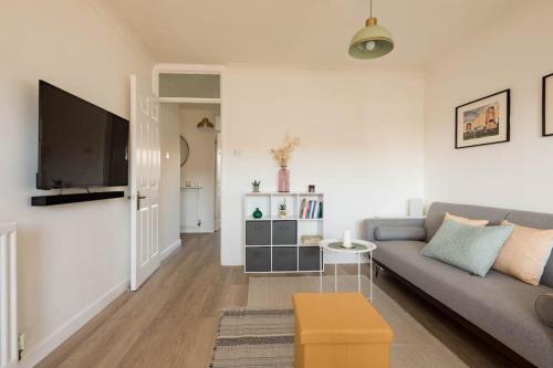 a living room with a couch and a tv at Stylish apartment with balcony, minutes from beach in Redcar