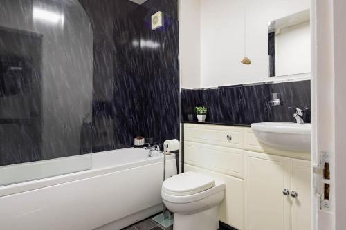 a bathroom with a white toilet and a sink at Stylish apartment with balcony, minutes from beach in Redcar