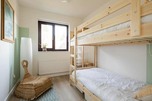 a bedroom with two bunk beds and a chair at Stylish apartment with balcony, minutes from beach in Redcar