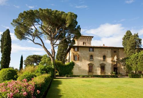 an old house with a tree in the yard at Hotel Torre di Bellosguardo in Florence