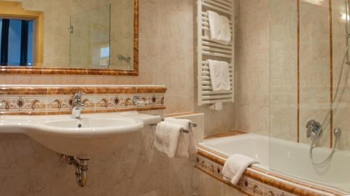 a bathroom with a sink and a tub at Abanico Appartements in Seefeld in Tirol