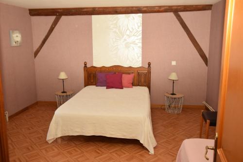 1 dormitorio con 1 cama blanca grande con almohadas rosas en Gite La Sente des Vignes, en Hauteville