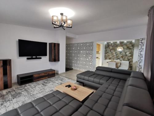 a living room with a couch and a flat screen tv at Rose Residence in Gura Humorului