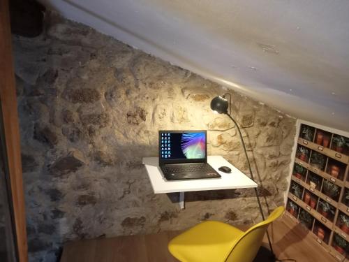 L'Atelier de Pierre Gîte Atypique في Saint-Cyr: وجود جهاز كمبيوتر محمول على مكتب في غرفة
