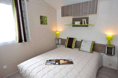Laroque-des-AlbèresにあるCamping Les Albères - Maevaのベッドルーム1室(白いベッド1台、本付)