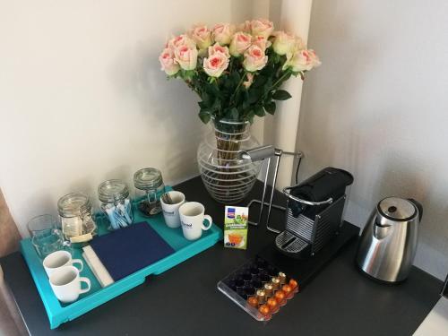 stół z wazą różowych róż i kawy w obiekcie Casa Koraal - Old Town Zug w mieście Zug
