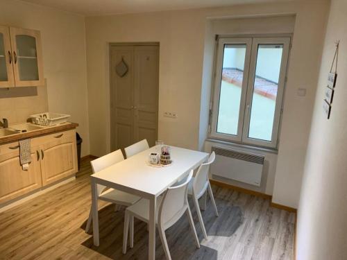 - une cuisine avec une table blanche et des chaises blanches dans l'établissement Ravissant Appartement T3 hypercentre de Mazamet, à Mazamet