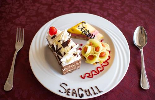 a white plate with two pieces of cake on it at Seagull Beach Resort - Families and Couples Only in Hurghada