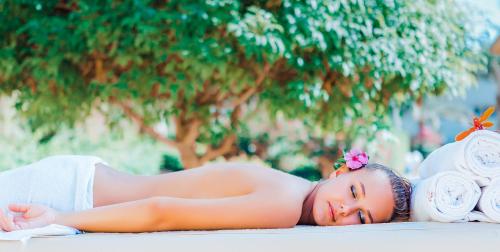 a woman laying on the ground next to towels at Seagull Beach Resort - Families and Couples Only in Hurghada