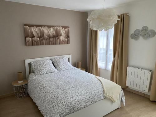 een slaapkamer met een wit bed en een raam bij Le Marais Vous - Duplex en centre-ville. in Provins