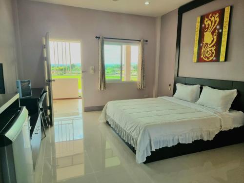 a bedroom with a large bed and a window at Chiangkham Grand Villa - SHA Certified in Chiang Kham