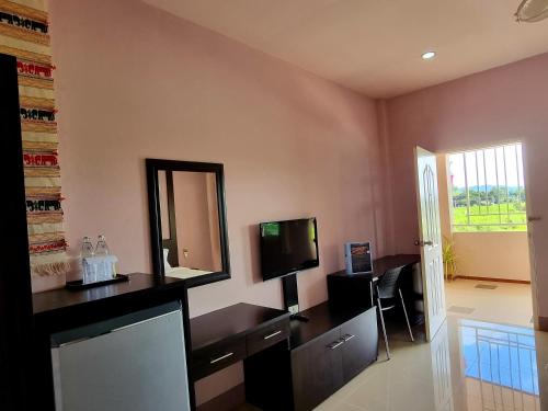a living room with a television and a mirror at Chiangkham Grand Villa - SHA Certified in Chiang Kham