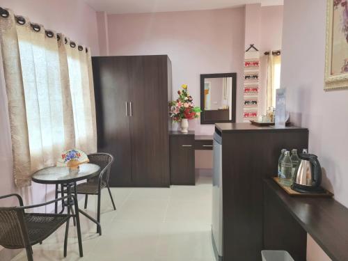a kitchen with a table and a small table with chairs at Chiangkham Grand Villa - SHA Certified in Chiang Kham