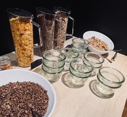a table topped with glasses and bowls of cereal at Sure Hotel by Best Western Bordeaux Lac in Bordeaux