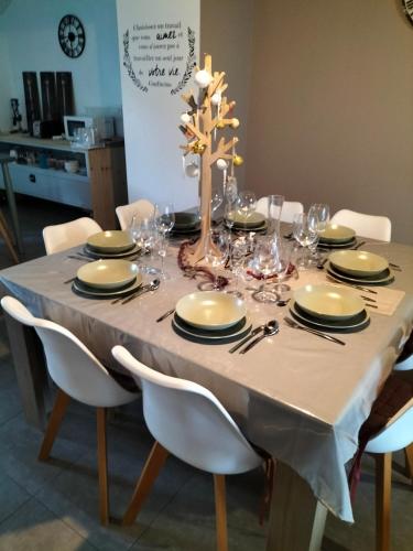 - une table à manger avec une nappe et des chaises blanches dans l'établissement Maison en pierre, à Bouvron