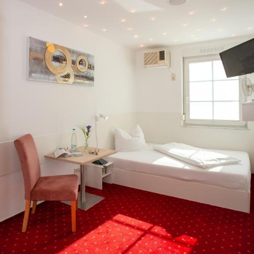 a room with a bed and a desk and a chair at Relax Hotel & SPA Stuttgart in Stuttgart