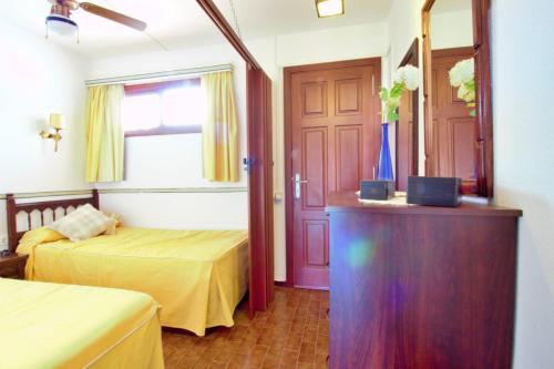 een slaapkamer met 2 bedden en een dressoir met een spiegel bij Studio with a canarian atmosphere in the south in Costa Del Silencio