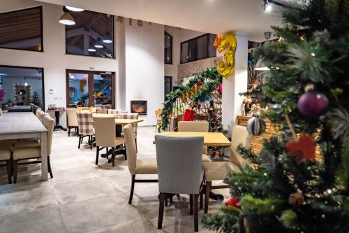 a christmas tree in a restaurant with tables and chairs at Къщички Синьо лято, Черноморец - Варна - Blue Summer Houses Varna in Varna City