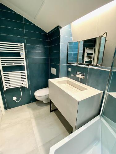 a bathroom with a sink and a toilet and a mirror at Le Capella, magnifique maison au calme avec garage in Caen