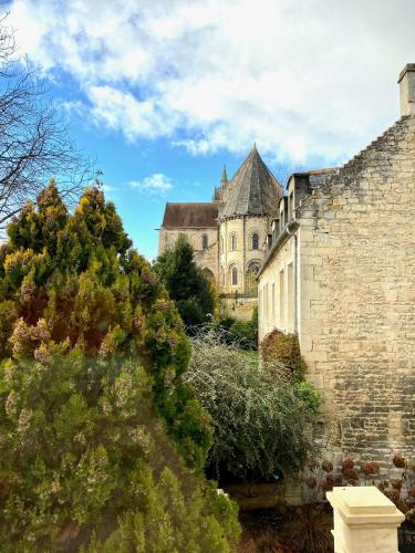 an old stone building with a tower in the background at Le Capella, magnifique maison au calme avec garage in Caen