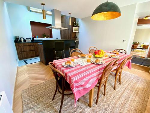 a dining room with a table with a pink table cloth at Le Capella, magnifique maison au calme avec garage in Caen