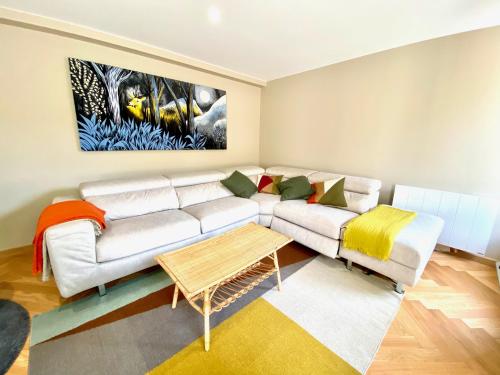 a living room with a white couch and a painting at Le Capella, magnifique maison au calme avec garage in Caen