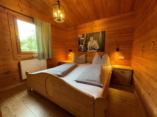 a bedroom with a bed in a wooden cabin at KNAUS Campingpark Viechtach in Viechtach