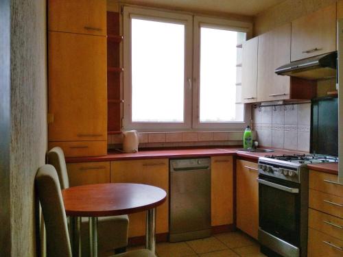 a kitchen with a table and a stove top oven at Noclegi - ul Śliczna in Wrocław