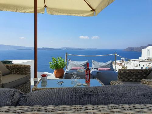 a patio with a table with a view of the ocean at Aqua & Terra Traditional Cave Houses in Oia
