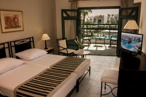 a bedroom with a bed and a view of a patio at JAZ Neo Naama Bay in Sharm El Sheikh