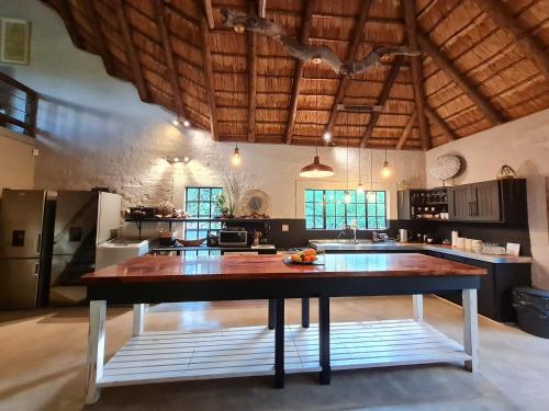 een grote keuken met een grote houten tafel bij Honey Badger Safari House in Marloth Park