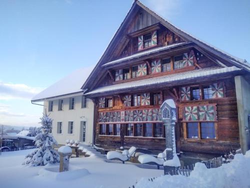 un gran edificio de madera con nieve en el suelo en Keiser`s Kammer, en Meisterschwanden