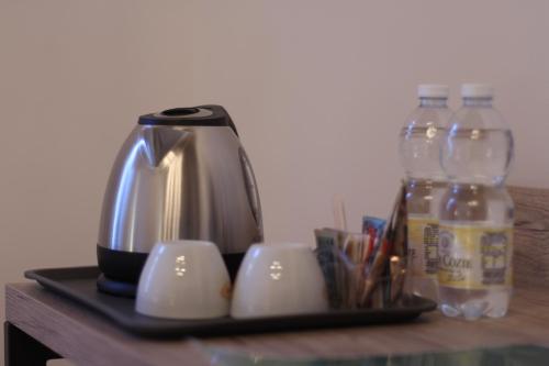 a tea kettle and bottles of water on a table at Hotel Tornielli 9 by LVG Hotel Collection in Novara
