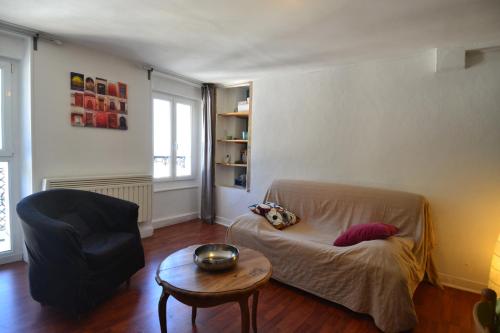 a living room with a couch and a chair and a table at APPARTEMENT LUZ ST SAUVEUR in Luz-Saint-Sauveur