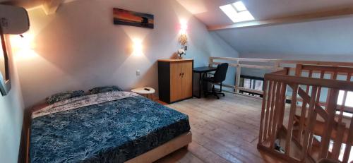 sypialnia z łóżkiem, biurkiem i schodami w obiekcie Appartement 3 pièces en duplex w mieście Antibes