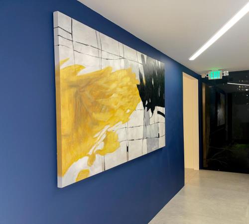 a large painting on a blue wall in a hallway at Park Plaza Lodge in Los Angeles