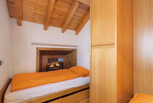 a bedroom with a bed with a fireplace in it at Chalet Gaste Big Family in Livigno