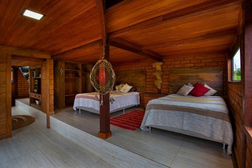 a bedroom with two beds in a wooden cabin at Sitio Jatoba/Lapinha da Serra in Santana do Riacho