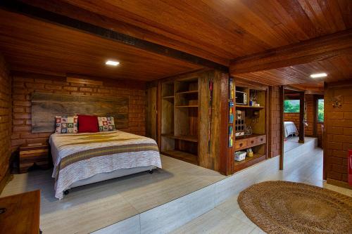 a bedroom with a bed in a wooden cabin at Sitio Jatoba/Lapinha da Serra in Santana do Riacho